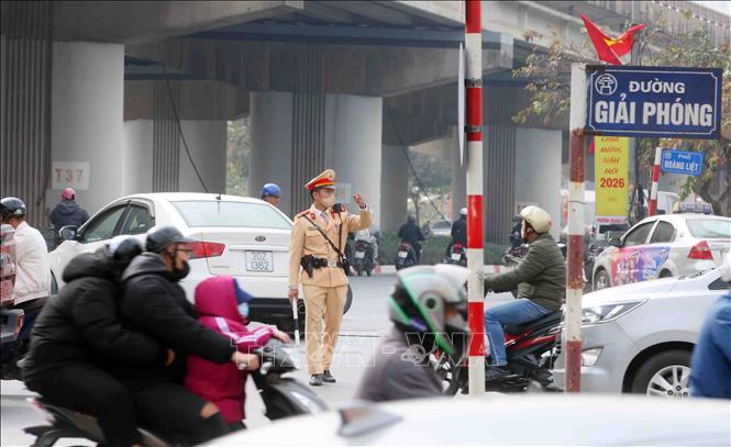 Cán bộ, chiến sĩ đội CSGT số 14 điều tiết, phân luồng giao thông tại tuyến đường Giải Phóng hướng về trung tâm thành phố. Ảnh: Phạm Kiên - TTXVN
