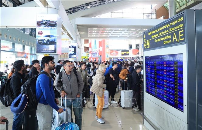 Hành khách kiểm tra thông tin chuyến bay nội địa tại Cảng HKQT Nội Bài, chiều 4/1. Ảnh: Quốc Khánh - TTXVN