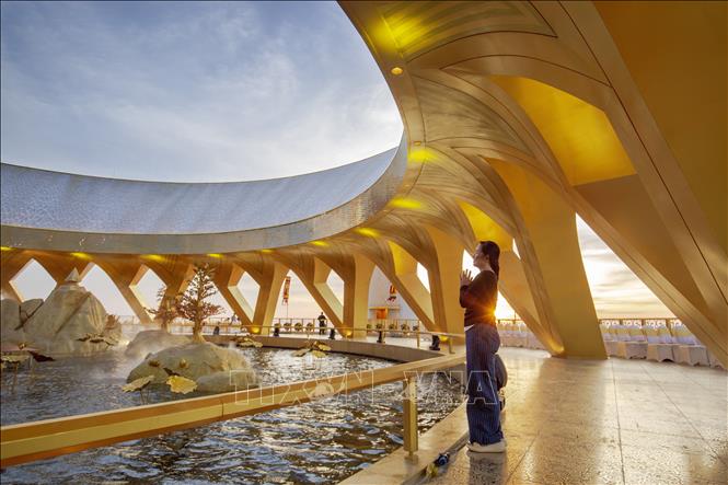 A visitor prays on the summit of Ba Den Mountain at sunset, sending wishes for peace and good fortune in the new year 2026. VNA Photo: Giang Phương