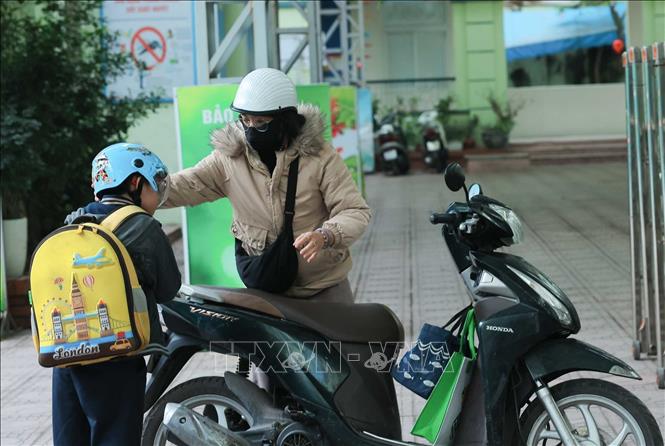 Học sinh được phụ huynh đưa đến trường trong ngày đầu tiên đi học năm 2026. Ảnh: Hoàng Hiếu - TTXVN
