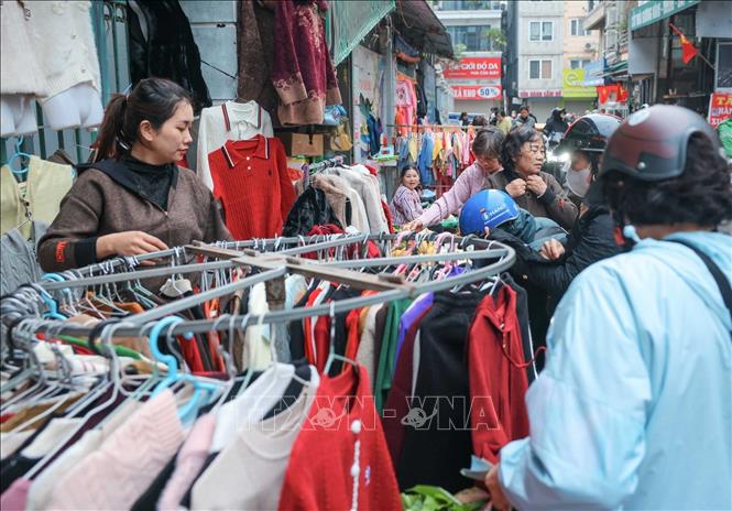 Tại các chợ dân sinh, nhiều người dân đã đến từ sớm mua đồ ấm khi thời tiết trở lạnh. Ảnh: Hoàng Hiếu - TTXVN