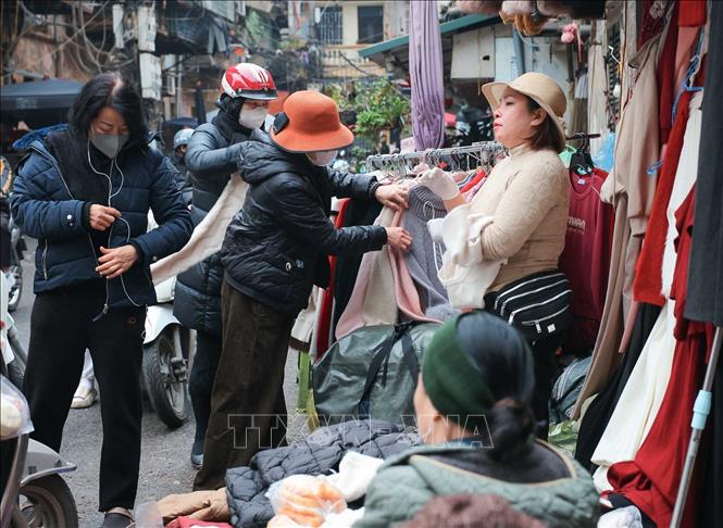 Tại các chợ dân sinh, nhiều người dân đã đến từ sớm mua đồ ấm khi thời tiết trở lạnh. Ảnh: Hoàng Hiếu - TTXVN