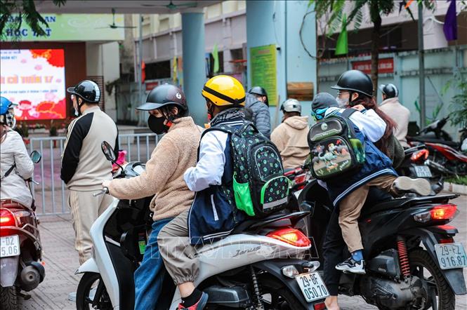 Học sinh được phụ huynh đưa đến trường trong ngày đầu tiên đi học năm 2026. Ảnh: Hoàng Hiếu - TTXVN