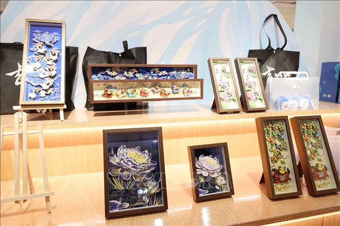 Những bức tranh được chế tác tinh xảo từ da cá hồ Tra Can. Ảnh: Công Tuyên-PV TTXVN tại Trung Quốc