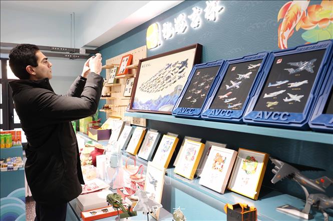 Du khách trong nước và quốc tế tìm hiểu về nghệ thuật chế tác tranh da cá của tỉnh Cát Lâm. Ảnh: Công Tuyên-PV TTXVN tại Trung Quốc