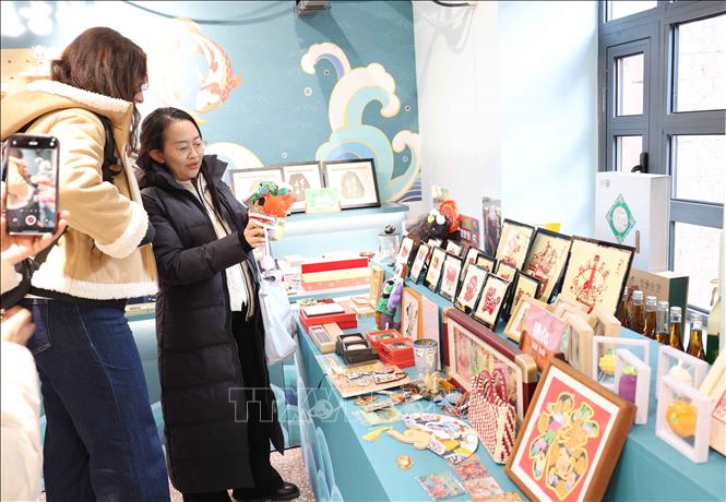 Du khách trong nước và quốc tế tìm hiểu về nghệ thuật chế tác tranh da cá ở tỉnh Cát Lâm. Ảnh: Công Tuyên-PV TTXVN tại Trung Quốc