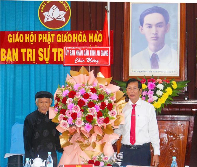 Phó Chủ tịch UBND tỉnh An Giang Lê Văn Phước (phải) tặng hoa mừng Ban Trị sự Trung ương Giáo hội Phật giáo Hòa Hảo. Ảnh: Công Mạo-TTXVN
