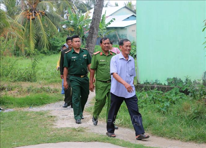 Các thành viên trong Đội dân phòng cùng Bộ đội Biên phòng và Công an phường Hà Tiên txuống nhà dân ở khu phố Xà Xía tuyên truyền, cảnh báo người dân về các thủ đoạn lừa đảo trên không gian mạng. Ảnh: Công Mạo-TTXVN 