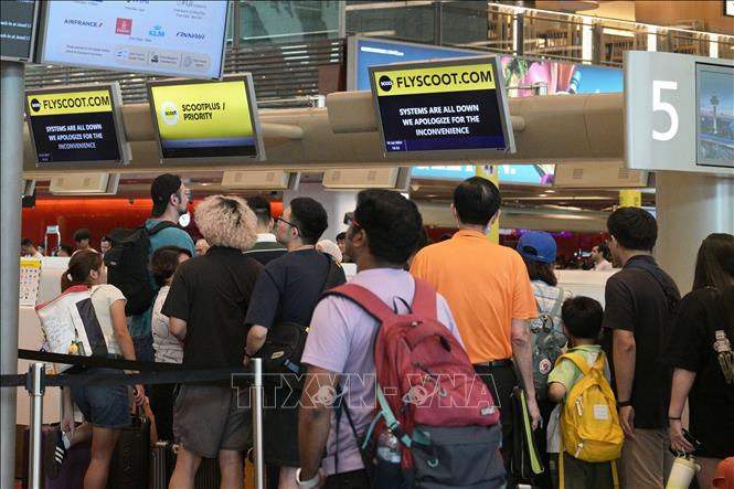 Hành khách xếp hàng tại quầy làm thủ tục ở sân bay Changi, Singapore. Ảnh: THX/TTXVN