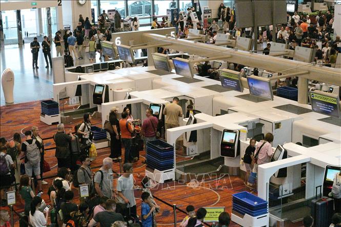 Hành khách xếp hàng tại quầy làm thủ tục ở sân bay Changi, Singapore. Ảnh: THX/TTXVN