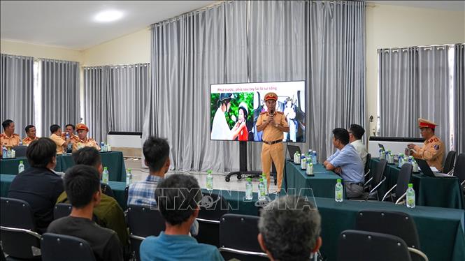 Phòng Cảnh sát giao thông Công an tỉnh Tây Ninh tuyên truyền,vận động lái xe, chủ phương tiện ký cam kết không chở quá khổ, quá tải tại nhà máy đường thuộc Công ty cổ phần Mía đường Thành Thành Công Tây Ninh. Ảnh: Minh Phú – TTXVN