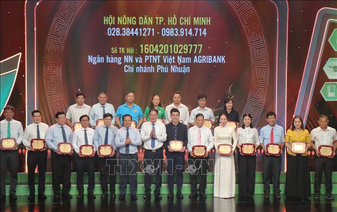 Lãnh đạo Thành phố Hồ Chí Minh tiếp nhận ủng hộ từ các đơn vị tài trợ. Ảnh: Thu Hương - TTXVN