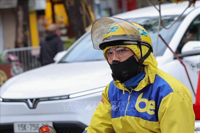 Tài xế xe công nghệ trang bị đầy đủ phụ kiện chống rét chuyên dụng, đảm bảo sức khỏe khi làm việc liên tục ngoài trời dưới nền nhiệt thấp. Ảnh: Vũ Quang - TTXVN