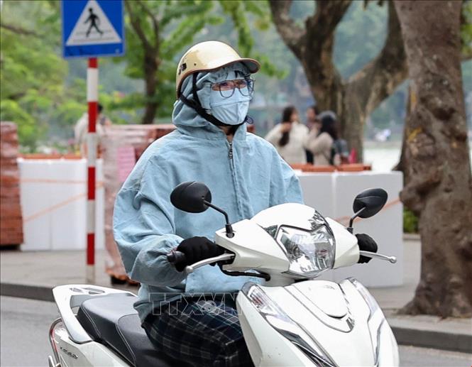 Người dân Hà Nội trang bị nhiều lớp áo ấm, khăn, khẩu trang khi di chuyển trên đường phố trong điều kiện nhiệt độ giảm sâu. Ảnh: Vũ Quang - TTXVN