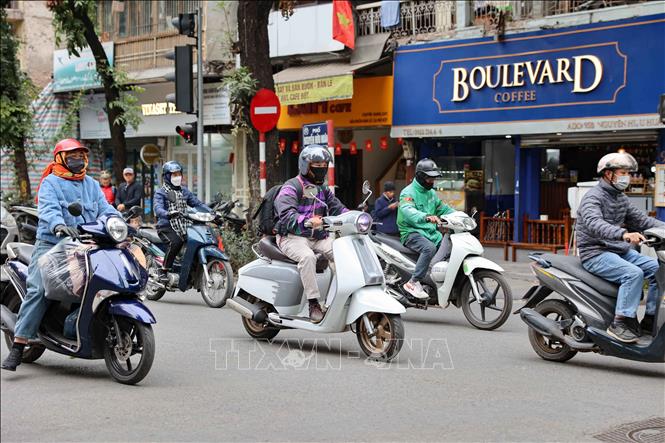 Người dân Thủ đô trang bị áo ấm, khăn len và khẩu trang kín khi di chuyển qua khu vực phố Nguyễn Hữu Huân trong sáng ngày rét đậm. Ảnh: Vũ Quang - TTXVN