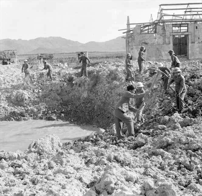 Ngay sau khi bom địch vừa dứt các chiến sĩ thanh niên xung phong đơn vị 551 có mặt kịp thời lấp hố bom thông đường cho xe ra tiền tuyến. Ảnh: TTXVN