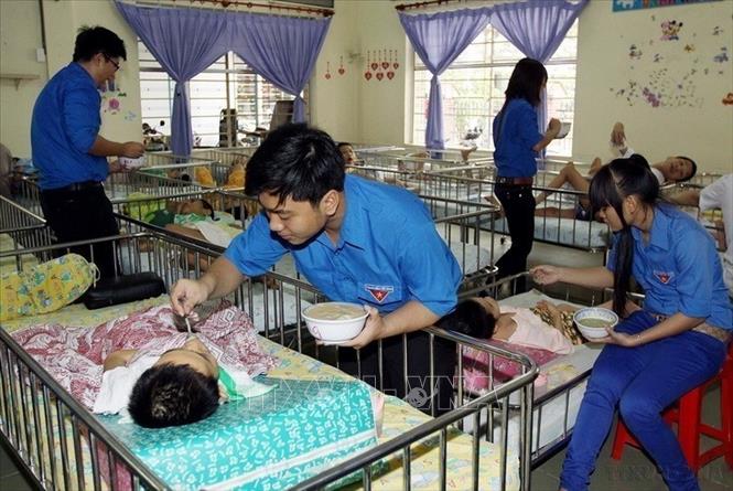 Đoàn viên thanh niên TP. Hồ Chí Minh chăm sóc trẻ khuyết tật tại Trung tâm Bảo trợ trẻ em tàn tật Thị Nghè. Ảnh: Thanh Vũ - TTXVN