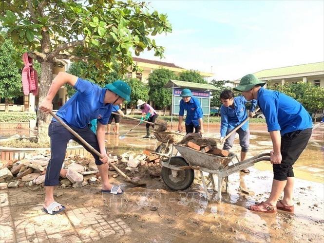 Lực lượng đoàn viên thanh niên huyện Đức Thọ (Hà Tĩnh) hỗ trợ huyện Thạch Hà vệ sinh, dọn dẹp sau khi lũ rút. Ảnh: Hoàng Ngà - TTXVN