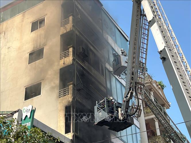 Lực lượng phòng cháy chữa cháy và CHCN phải dùng xe thang để tiếp cận khu vực cháy. Ảnh: Thành Phương - TTXVN