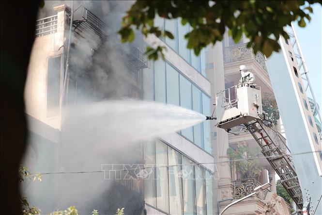 Lực lượng PCCC và CHCN đang nỗ lực dập tắt đám cháy tại nhà dân ở phố Lê Lợi, phường Hà Đông, Hà Nội. Ảnh: Lê Đông - TTXVN