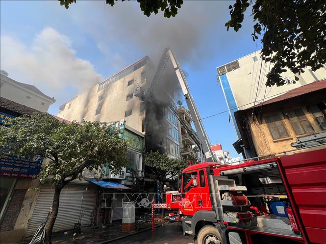 Do địa hình là nhà ống nên gây rất nhiều khó khăn cho lực lượng chức năng đang nỗ lực dập tắt đám cháy. Ảnh: Thành Phương - TTXVN