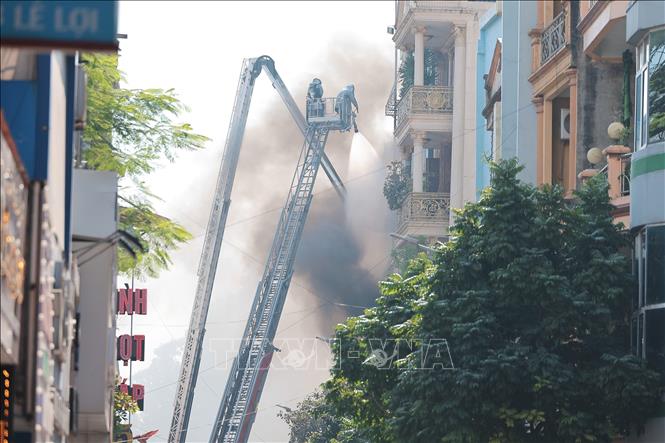 Do địa hình là nhà ống nên gây rất nhiều khó khăn cho lực lượng chức năng đang nỗ lực dập tắt đám cháy. Ảnh: Lê Đông - TTXVN