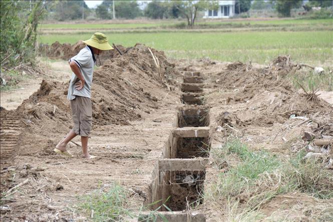Người dân xã Hàm Thuận Bắc (Lâm Đồng) triển khai nạo vét bùn đất trên các kênh bị mưa lũ vùi lấp để chuyển nước về cung cấp cho mùa vụ mới. Ảnh: Nguyễn Thanh - TTXVN