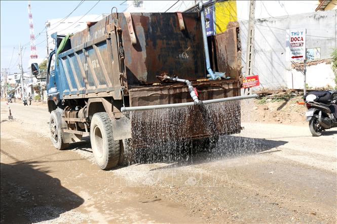 Đơn vị thi công đường Thủ Khoa Huân thực hiện tưới nước, giảm thiểu bụi bẩn ảnh hưởng nhà dân. Ảnh: Nguyễn Thanh - TTXVN