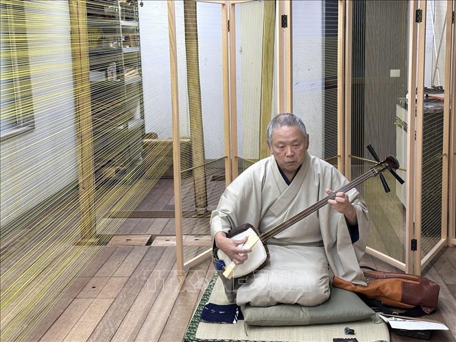 Nghệ sĩ đàn shamisen Gashu Toyozawa đang thử âm của dây đàn shamisen tại xưởng Marusan Hashimoto. Ảnh: Nguyễn Tuyến – PV TTXVN tại Nhật Bản