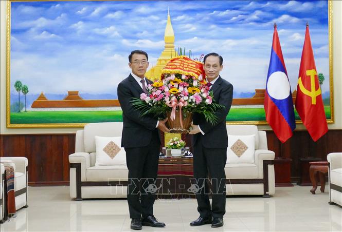 Đặc phái viên của Tổng Bí thư Tô Lâm, đồng chí Lê Hoài Trung chúc mừng Trưởng Ban Đối ngoại Trung ương Đảng NDCM Lào Bounleua Phandanouvong. Ảnh: Xuân Tú - PV TTXVN tại Lào