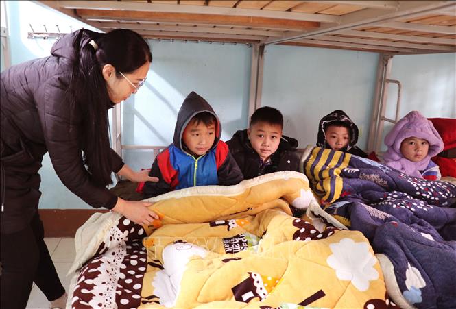 Thầy cô giáo giữ ấm giấc ngủ cho các em học sinh Trường PTDT Bán trú Tiểu học xã biên giới Tùng Vài (Tuyên Quang) trong những ngày giá rét. Ảnh: Đức Thọ - TTXVN