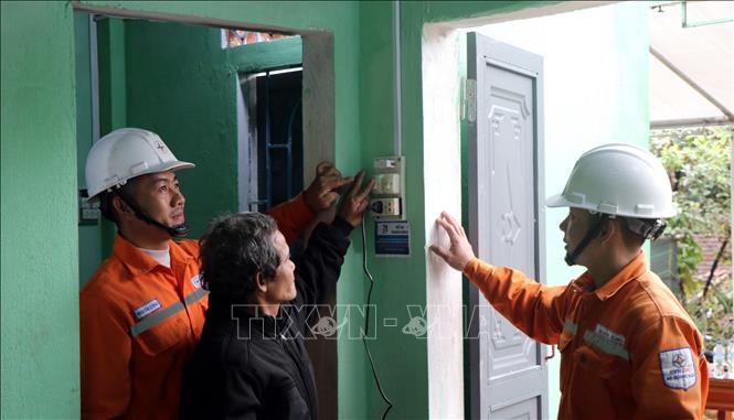 Assisting locals use electric devices in their new houses. VNA Photo: Cao Nguyên