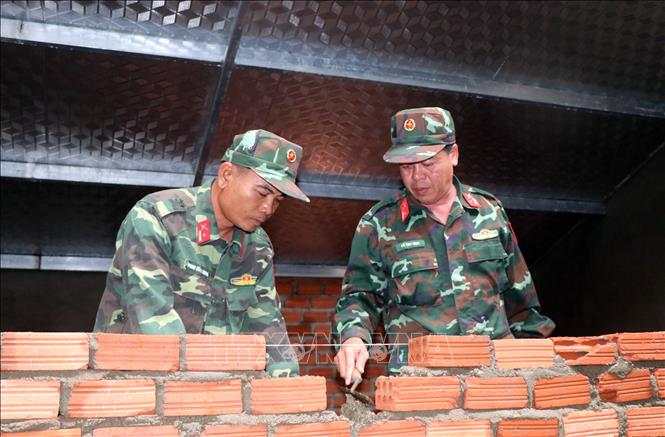 Police and army forces as well as local militia, authorities and residents join hands in rebuilding damaged houses. VNA Photo: Cao Nguyên