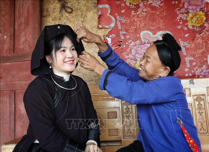 Người dân sinh sống trong khu nhà cổ vẫn duy trì nếp sống truyền thống, mặc trang phục dân tộc trong sinh hoạt hằng ngày. Ảnh: Danh Lam -TTXVN 