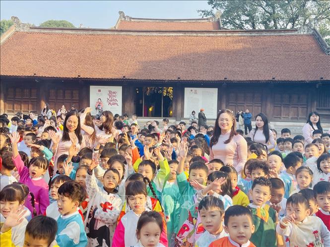 Các em học sinh háo hức, phấn chấn chờ đến giờ diễu hành. Ảnh: Tuyết Mai - TTXVN