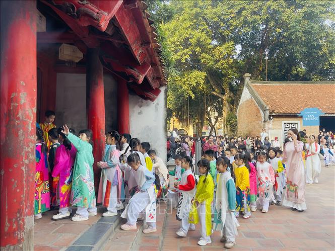 Các em học sinh diễu hành từ khu nội tự Văn Miếu – Quốc Tử Giám sang Hồ Văn. Ảnh: Tuyết Mai - TTXVN