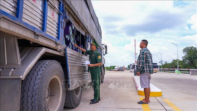 Cán bộ Trạm kiểm soát liên hợp cửa khẩu quốc tế Tân Nam kiểm tra xe container trước khi cho thông quan qua cửa khẩu. Ảnh: Minh Phú - TTXVN
