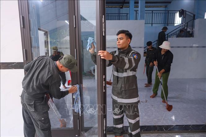 Cán bộ, chiến sĩ Trung tâm Huấn luyện, bồi dưỡng nghiệp vụ và giáo dục nghề nghiệp số 3 – Bộ Tư lệnh Cảnh sát cơ động giúp dân vệ sinh nhà cửa để chuẩn bị về nhà mới tại xã Thượng Đức (Đà Nẵng). Ảnh: Trần Lê Lâm - TTXVN 
