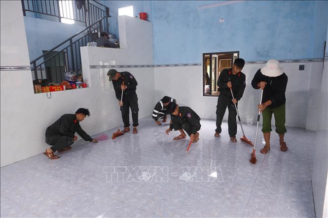 Cán bộ, chiến sĩ Trung tâm Huấn luyện, bồi dưỡng nghiệp vụ và giáo dục nghề nghiệp số 3 – Bộ Tư lệnh Cảnh sát cơ động giúp dân dọn vệ sinh nhà vừa mới xây để chuẩn bị về nhà mới tại xã Thượng Đức. Ảnh: Trần Lê Lâm - TTXVN 