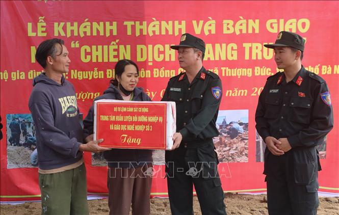 Thượng tá Phạm Hồng Phúc (phải) Phó Giám đốc Trung tâm Huấn luyện, bồi dưỡng nghiệp vụ và giáo dục nghề nghiệp số 3 – Bộ Tư lệnh Cảnh sát cơ động tặng quà chúc mừng hộ gia đình ông Nguyễn Định tại xã Thượng Đức trong ngôi nhà mới do cán bộ, chiến sĩ Trung tâm xây dựng. Ảnh: Trần Lê Lâm - TTXVN 