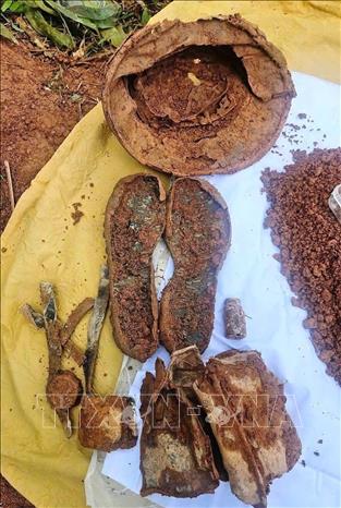 Các hài cốt được tìm thấy kèm theo các di vật như: mũ cối, giày, thắt lưng, võng bộ đội, hộp tiếp đạn, đạn AK và các đồ dùng cá nhân…. Ảnh: TTXVN phát