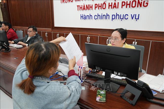 Cán bộ trung tâm hướng dẫn thủ tục cho người dân. Ảnh Tiến Vĩnh  - TTXVN 