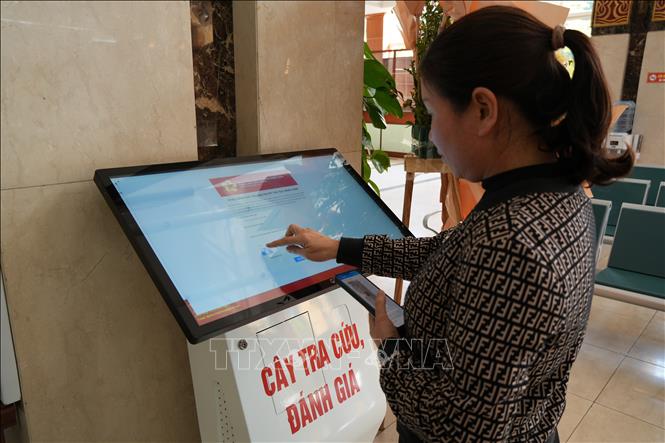 Người dân đánh giá chất lượng dịch vụ tại cây đánh giá của trung tâm. Ảnh Tiến Vĩnh  - TTXVN 