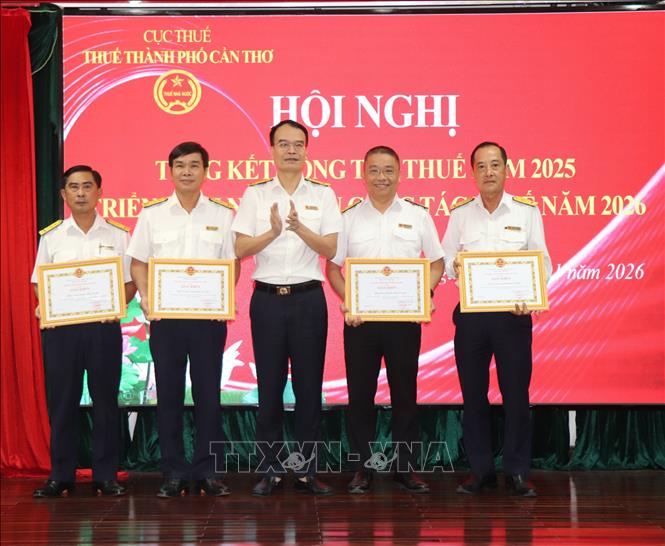 Ông Phan Tiến Lân, Trưởng Thuế thành phố Cần Thơ tặng Giấy khen của Thuế thành phố cho các đơn vị trực thuộc. Ảnh: Thu Hiền - TTXVN