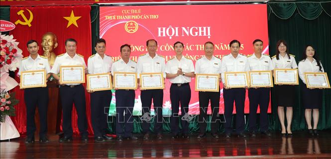 Đại diện lãnh đạo Thuế thành phố Cần Thơ tặng giấy khen cho các tập thể, cá nhân thực hiện Đề án “Chuyển đổi mô hình và phương pháp quản lý thuế đối với hộ kinh doanh khi xóa bỏ thuế khoán”. Ảnh: Thu Hiền - TTXVN