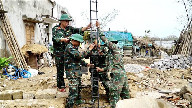 Lực lượng quân đội thực hiện xây nhà cho người dân vùng lũ ở Gia Lai
Ảnh: Sỹ Thắng/TTXVN