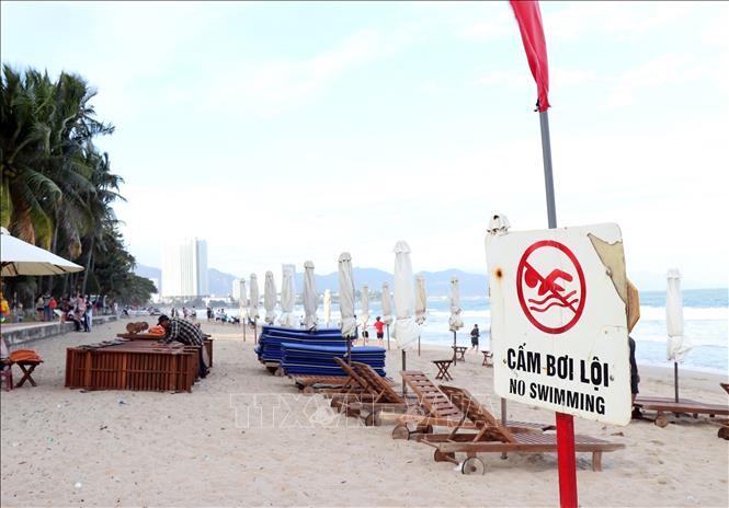 Lực lượng chức năng cắm biển cảnh báo nguy hiểm khi tắm biển
Ảnh: Công Thử - TTXVN