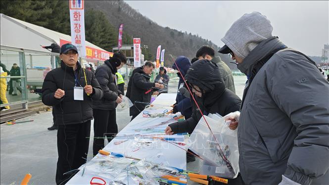 Du khách được phát cần câu và túi nylon đựng cá tại cửa vào khu vực câu cá trên băng. Ảnh: Đức Thắng - Pv TTXVN tại Hàn Quốc 