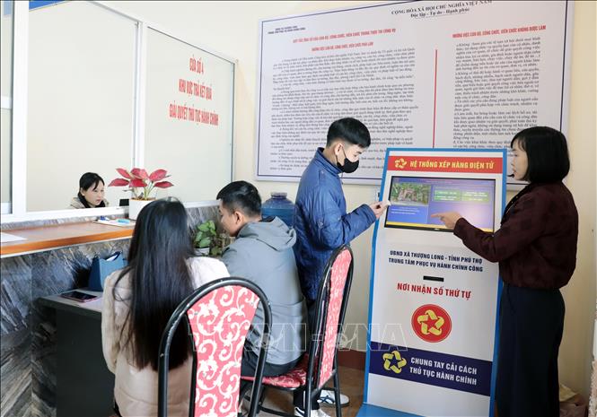 Cán bộ Trung tâm Hành chính công xã Thượng Long hướng dẫn người dân thực hiện thủ tục hành chính. Ảnh: Tạ Toàn – TTXVN