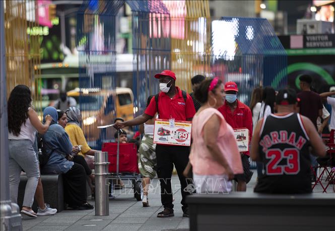 Nhân viên phát tờ rơi tại New York, Mỹ. Ảnh: THX/TTXVN